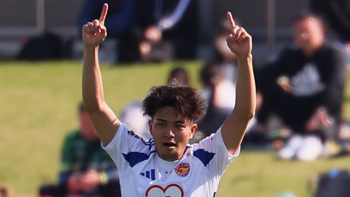 両手の人差し指を高らかに青空へ突きあげた五十嵐聖己